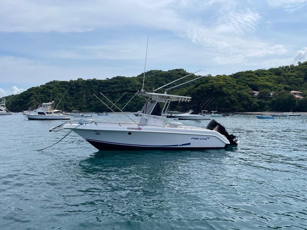 The Fearless Adventures center-console boat anchored in a bay near Playas del Coco